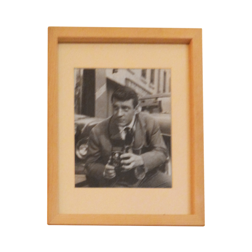 Fotografía en blanco y negro de hombre sujetando cámara antigua