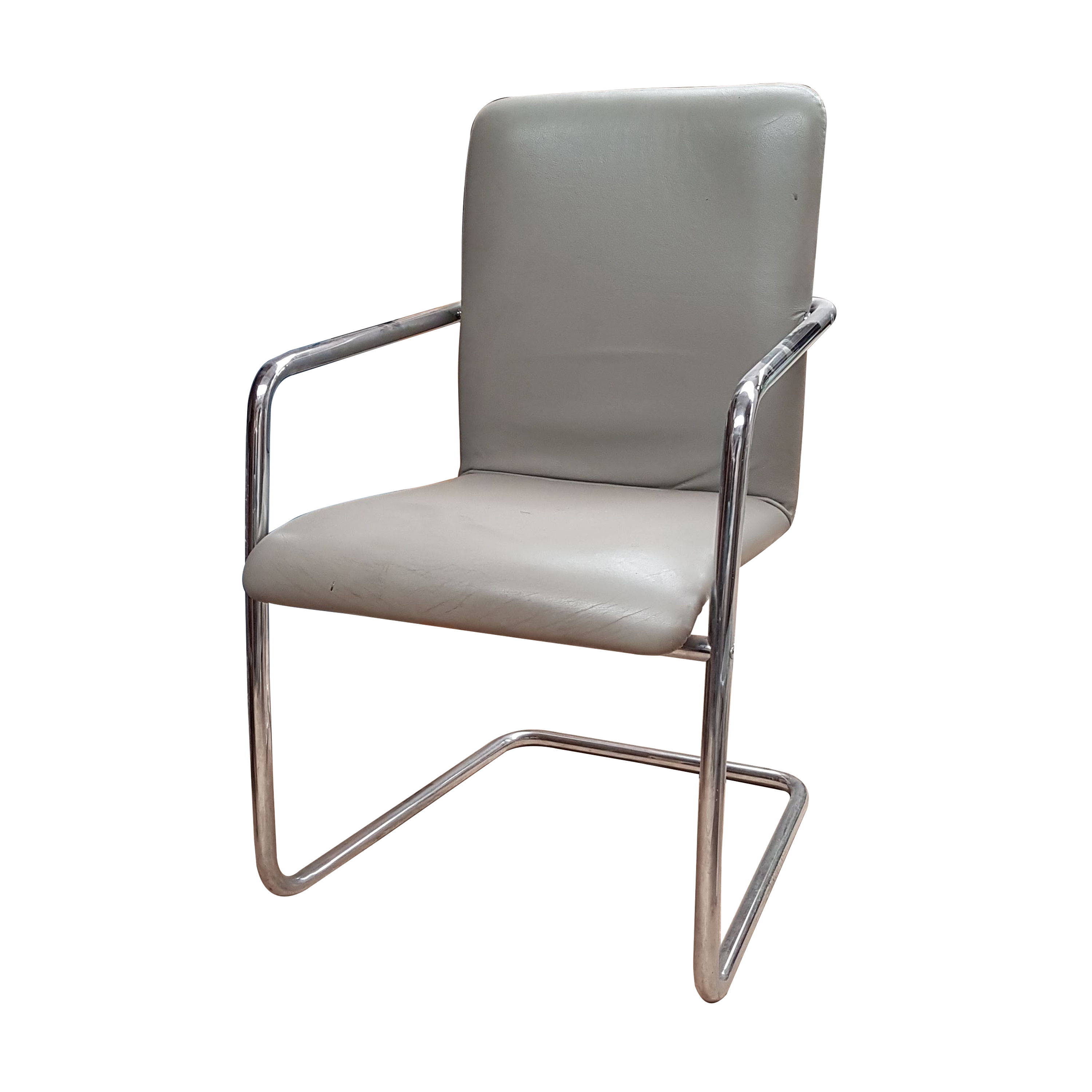 Sillón en metal cromado con tapicería de piel gris.