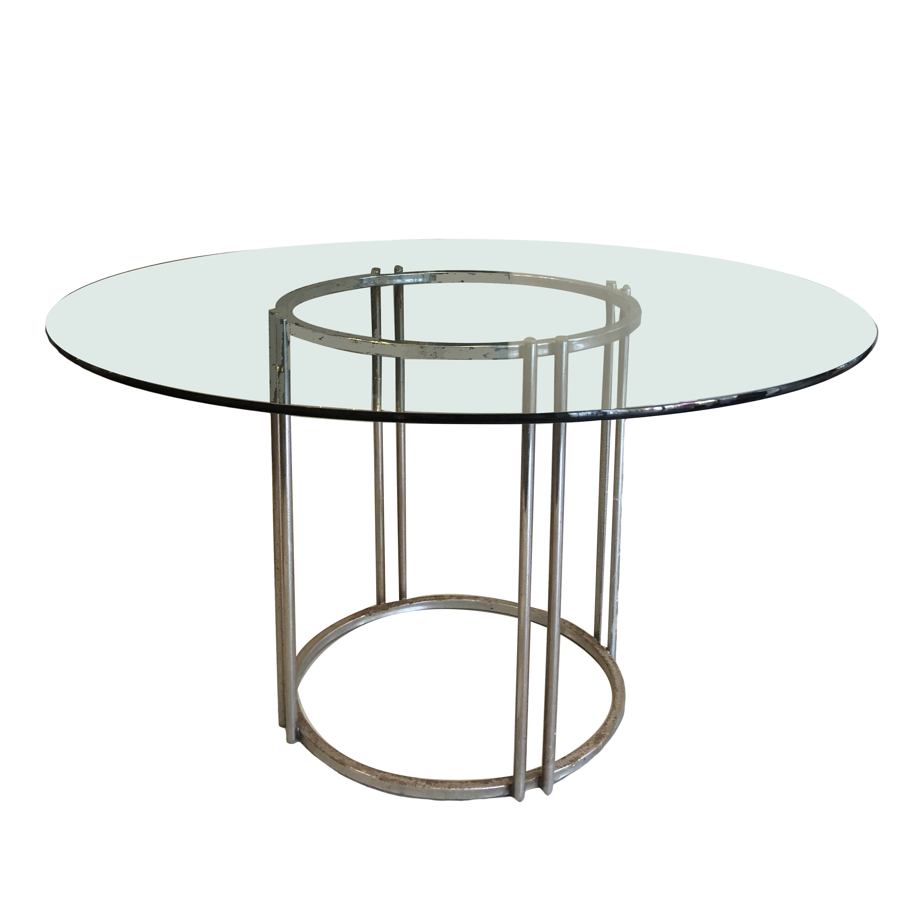 Mesa de comedor en acero cromado con cubierta circular de vidrio.