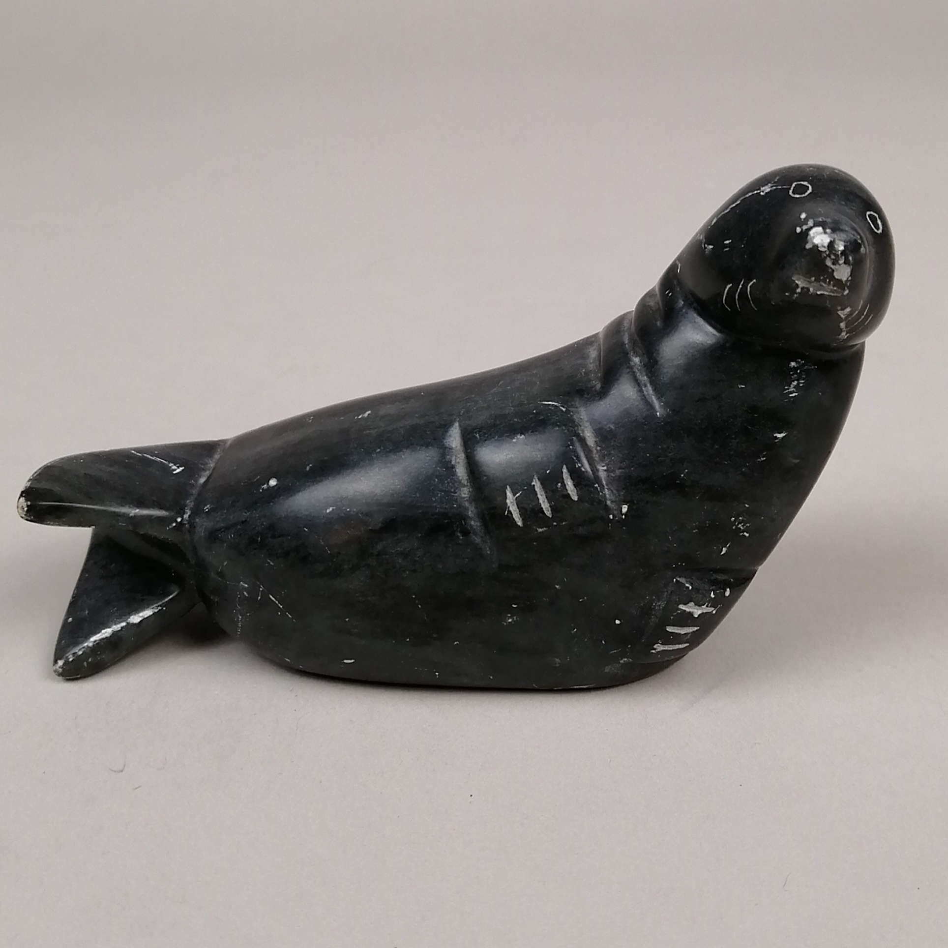 Escultura de foca en marmol negro.
